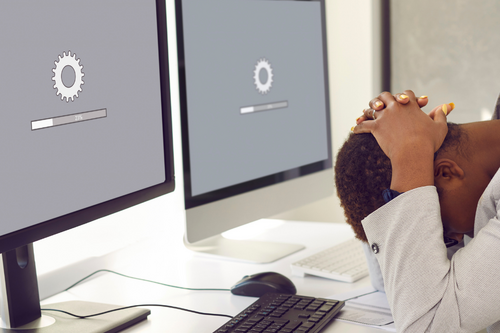 Image of someone frustrated over a slow computer.