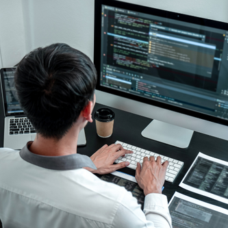 Man programming on computer and monitor